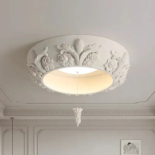 Artistic carved plaster chandelier with white LED lights.