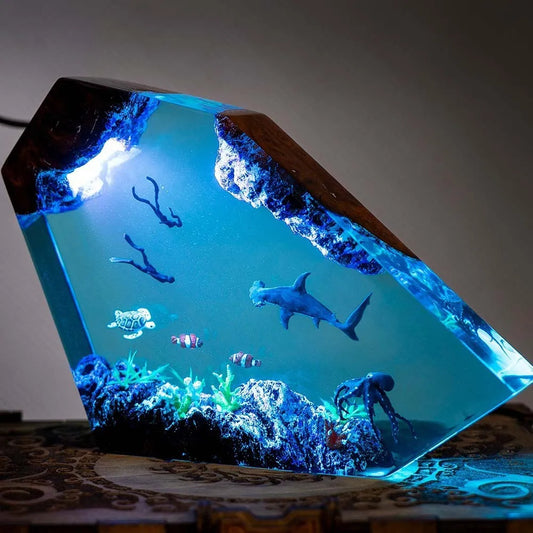 Decorative lamp made of epoxy resin in the shape of a small humpback whale looking out at the sea.