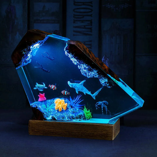 Decorative lamp made of epoxy resin in the shape of a small humpback whale looking out at the sea.