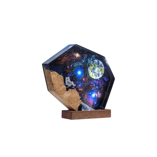 A plastic night light in the shape of a galaxy with wooden astronaut motifs.
